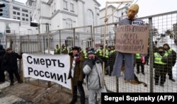A mannequin depicting Russian President Vladimir Putin is hung on a gallows with a sign reading "Death to Putin, death to the racist occupier" during a rally outside the Russian Consulate in Kyiv on March 18.