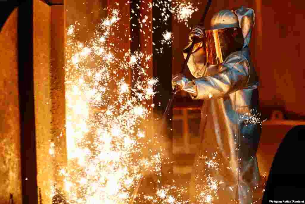 A steel worker stands amid sparks of raw iron coming from a blast furnace at a ThyssenKrupp factory in Duisburg, Germany. (Reuters/Wolfgang Rattay)