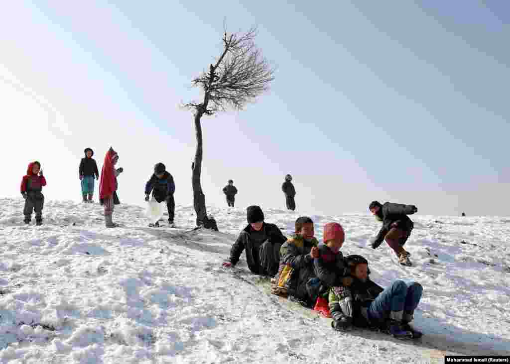 Afghan boys slide down a snow-covered slope in Kabul. (Reuters/Mohammad Ismail)