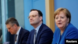 Angela Merkel împreună cu ministrul Sănătății și șeful Institutului Robert Koch