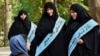 Female members of the notorious morality police known as the Guidance Patrols stop to talk to a woman in Tehran. 