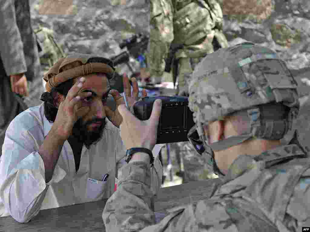 A U.S. Army soldier scans the eyes of an Afghan man for a biometric ID system near the border with Pakistan. (AFP PHOTO/Tauseef Mustafa)