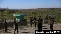Afghan security personnel keep watch at the site of an attack by Taliban militants on a government compound in the Khwaja Omari district in the southeastern province of Ghazni on April 12.