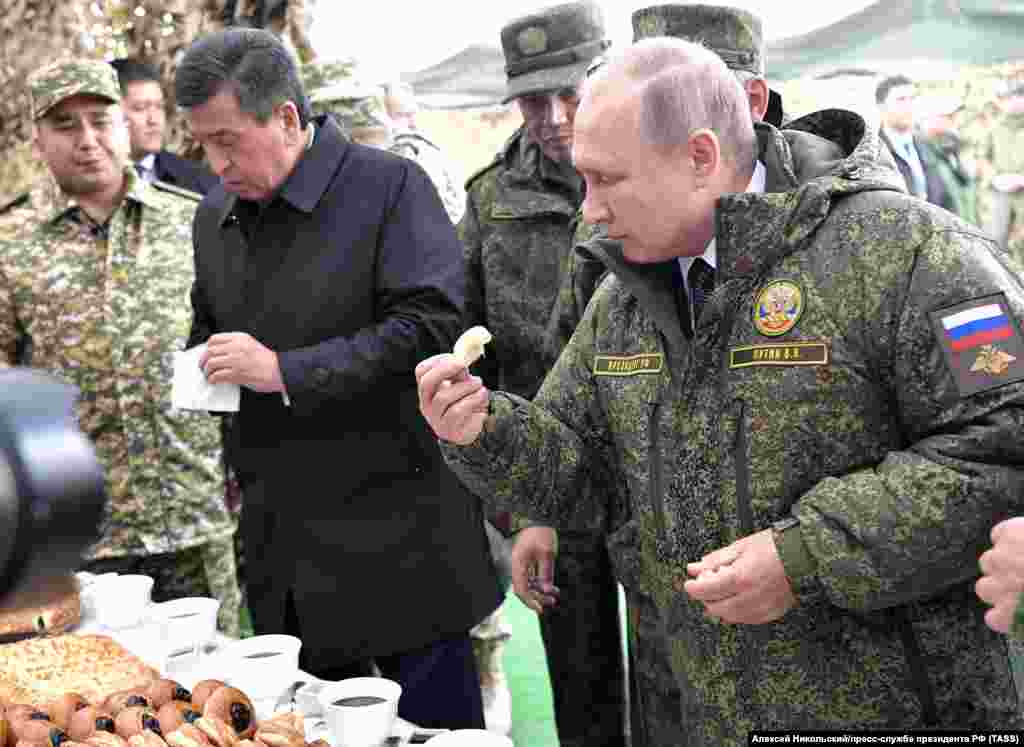 Kyrgyz President Sooronbai Jeenbekov (left) and Vladimir Putin grab a bite to eat after observing the maneuvers. Jeenbenkov was the only foreign leader to attend the exercises.