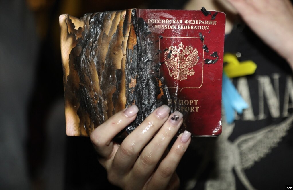დემონსტრანტი თავის რუსულ პასპორტს წვავს ისრაელში, თელ-ავივში, რუსეთის საელჩოს წინ. 24 თებერვალი.
