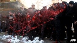 Protesters splash police with red paint during a February 7 rally for the resignation of Pristina University's rector.