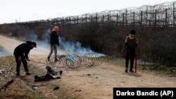Мігранти намагаються розрізати паркан на турецько-грецькому кордоні під час сутичок із грецькою поліцією неподалік від пункту перетину Пазаркуле, Туреччина, 2 березня 2020 року