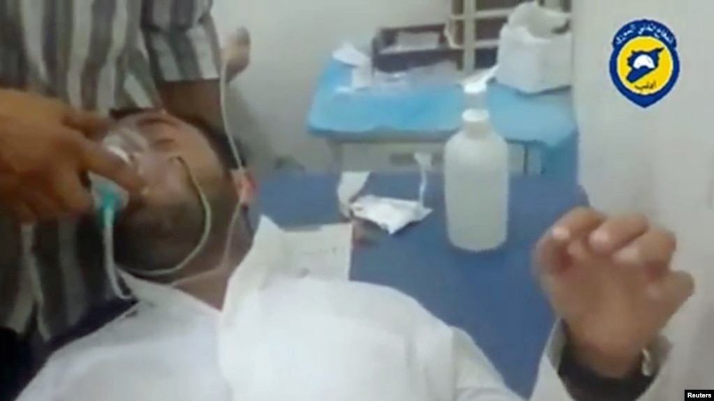 Врач оказывает помощь пострадавшему во время химической атаки в Сирии 