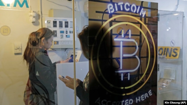Prolaznici koriste bankomat za bitcoin u Hong Kongu