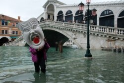 Чоловік із маскою ходить по затопленій вулиці у Венеції. Щорічну сезонну повінь мешканці міста називають «високою водою» (acqua alta), але цьогоріч вона сягнула небувалих розмірів