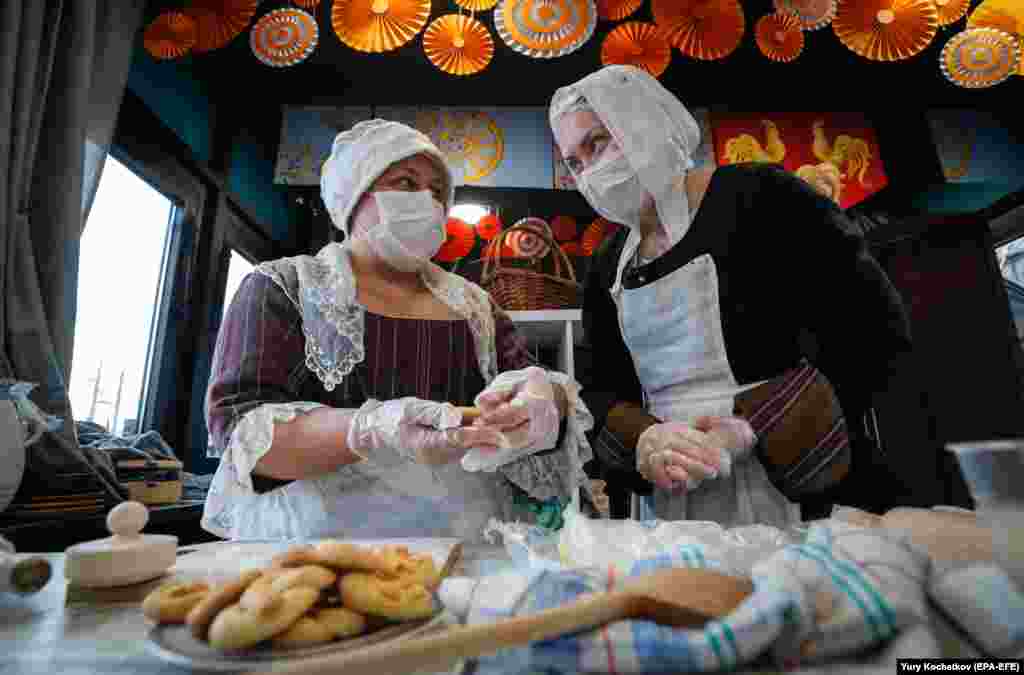 Costumed actresses wear antiviral masks while attending the Maslenitsa festival in Moscow.