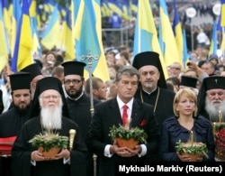 Вселенський патріарх Варфоломій (другий зліва), президент України Віктор Ющенко (четвертий зліва), його дружина Катерина (друга справа) та представники церкви відвідують пам’ятник жертвам Голодомору-геноциду в Україні у 1932 –1933 роках. Київ, 26 липня 2008 року