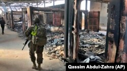 U.S. Soldiers walk past a site of Iranian bombing at Ain al-Asad air base, in Anbar, January 13, 2020.