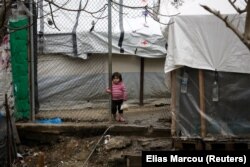 Një vajzë migrante, qëndron pranë një kampi në Lesbos të Greqisë. Fotografi nga arkivi.