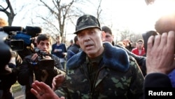 Ukrainian General Vasyl Krutov (center) talks to journalists in front of the airbase in Kramatorsk in eastern Ukraine on April 15.