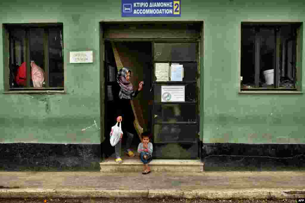 A child sits at the entrance of a building at the refugee camp of Schisto in Athens, Greece. (AFP/Aris Messinis)