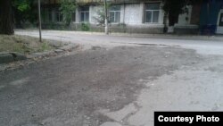 Фото автора: засыпанная срезанным асфальтом с главной дороги Донецк – Луганск яма на перекрестке с ней