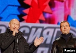 President Vladimir Putin (left) points to then-First Deputy Prime Minister Dmitry Medvedev as he addresses the crowd at a concert in Moscow in March 2008.