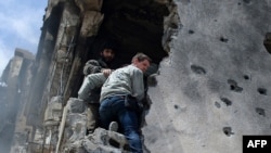 A photograph shortly before he was killed shows Tim Hetherington (center) being assisted by rebels as he climbs down a building after gunshots rang out in the besieged Libyan city of Misurata on April 20.