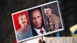 Joszif Sztálint, Vlagyimir Putyint és Adolf Hitlert ábrázoló transzparens egy háborúellenes tüntetésen 2022. február 27-én