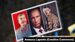 Joszif Sztálint, Vlagyimir Putyint és Adolf Hitlert ábrázoló transzparens egy háborúellenes tüntetésen 2022. február 27-én