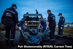 Українські рятувальники збирають тіла загиблих на місці падіння «Боїнга», селище Грабове, 20 липня 2018 року