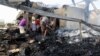 Yemen -- Yemeni men inspect the damages at a factory allegedly targeted by Saudi-led coalition's airstrikes in the Red Sea town of Hodeidah on July 27, 2018. / AFP PHOTO / ABDO HYDER