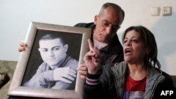 The parents of 19-year-old Muhammad Musallam (shown in the portrait) react to the news of his reported killing at the family's home in the East Jerusalem Jewish settlement of Neve-Yaakov.