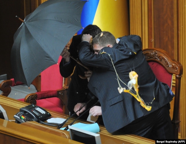 Володимира Литвина, голову Верховної Ради, прикривають парасольками під час голосування за «Харківські угоди»