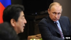 Russian President Vladimir Putin (right) and Japanese Prime Minister Shinzo Abe talk during their meeting in Sochi on May 6. 