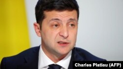 Ukraine's President Volodymyr Zelenskiy speaks during a press conference after the Paris summit. Activists in Ukraine says Zelenskiy crossed no “red lines” in his talks with Putin.
