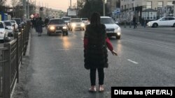 Женщина ловит такси на остановке «Гиперхаус». Шымкент, 13 ноября 2019 года.