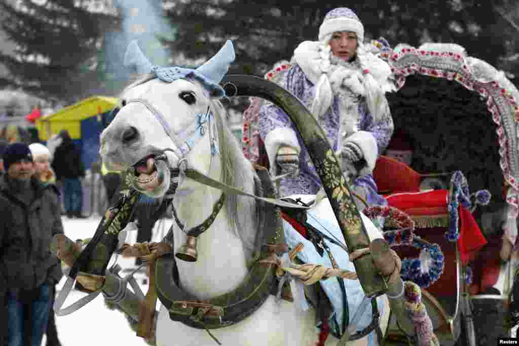 A Russian woman in costume rides a horse with a cart during New Year celebrations in the Siberian city of Krasnoyarsk on January 2. (Reuters/Ilya Naymushin)