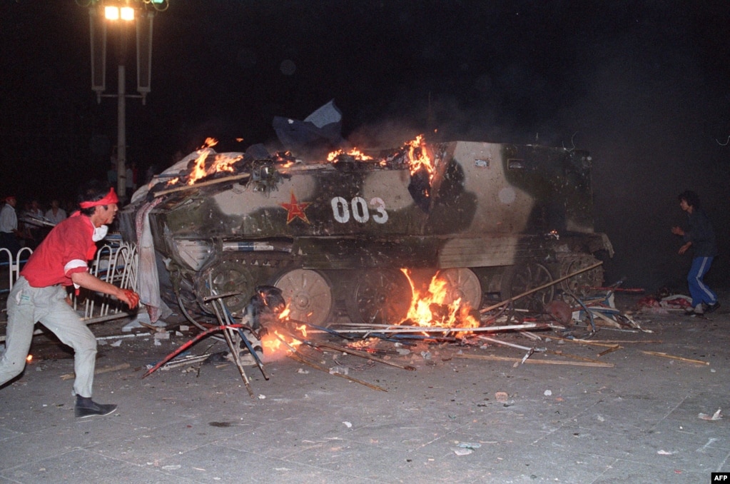 On the night of June 3, troops began to move against the protesters with tanks and armored vehicles. In this photo from June 4, students set an armored personnel carrier on fire.