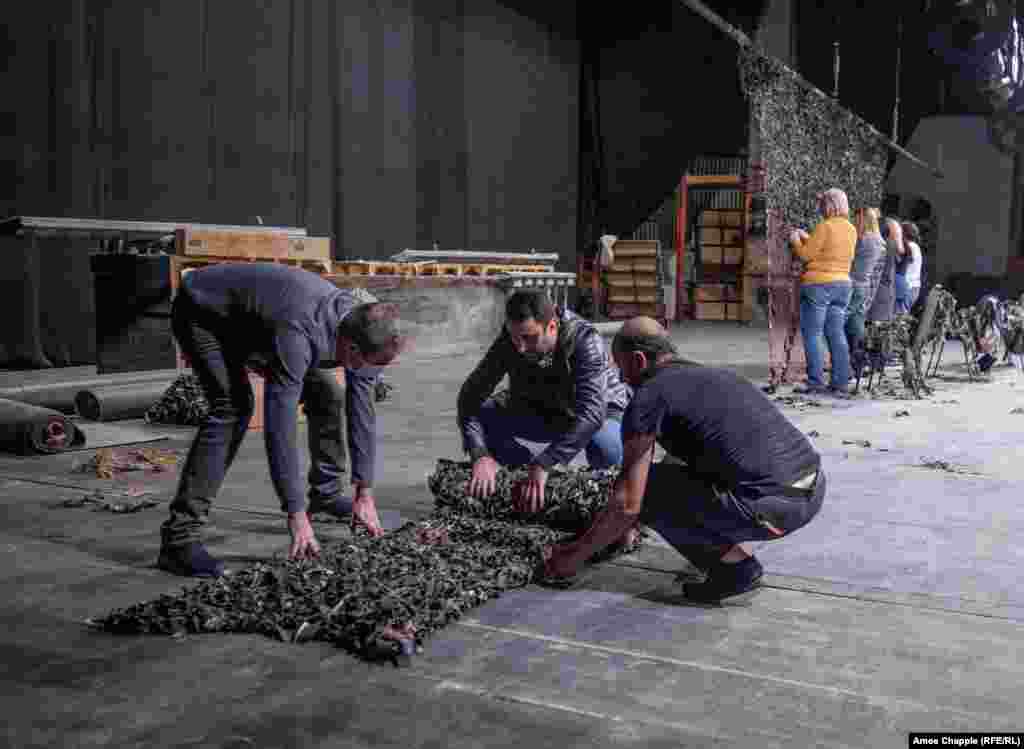 to make sheets of camouflage netting. This completed net is being rolled up before delivery to Armenia’s frontline troops.
