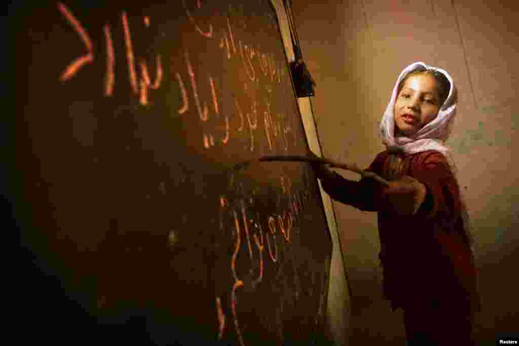 A girl reads from the board in a home-based school in Kabul in December 2001. The Taliban had enforced a prohibition on education for women.