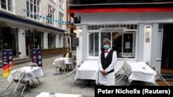 Konobar ispred restorana u Londonu, juli 2020. 