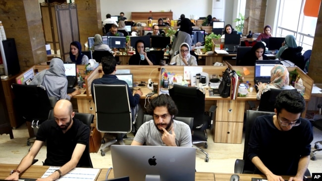 Snapp online taxi company work at their office in Tehran May 23, 2017 (AP Photo/Ebrahim Noroozi)