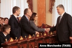 Ukrainian President Petro Poroshenko (right) shakes hands with new judges from Ukraine's High Anti-Corruption Court during an oath-taking ceremony on April 11.