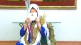 Turkmenistan. Screen grab of woman kissing the money gift for Woman international day. March 2016