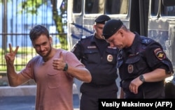 Pyotr Verzilov walks with police during a court hearing at a courthouse in Moscow on July 31, 2018.