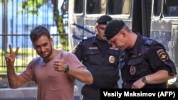 Pyotr Verzilov gestures to supporters while making an appearance in court in Moscow in July. (file photo)