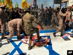 Силы народной мобилизации Ирака сжигают флаги США и Израиля во время дня «аль-Кудс» (на арабском языке Иерусалим) в Багдаде. Ирак, 31 мая 2019 года
