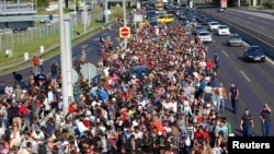 Мигранты идут по автомагистрали из Венгрии к границе с Австрией 