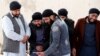 FILE: Afghan Sikh men mourn during funeral for the victims who were killed during a March 25 attack on a Sikh Gurdwara in Kabul.