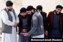 Afghan Sikh men mourn during funeral for the victims who were killed during a March 25 attack on a Sikh gurdwara in Kabul.