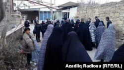 Специальные силы безопасности, в том числе женщины полицейские разговаривают с верующими женщинами поселка Нардаран. Баку, 1 декабря 2015 года.
