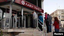 People line up to make a transaction at an ATM outside a branch of Laiki Bank in Nicosia, Cyprus, on March 21.