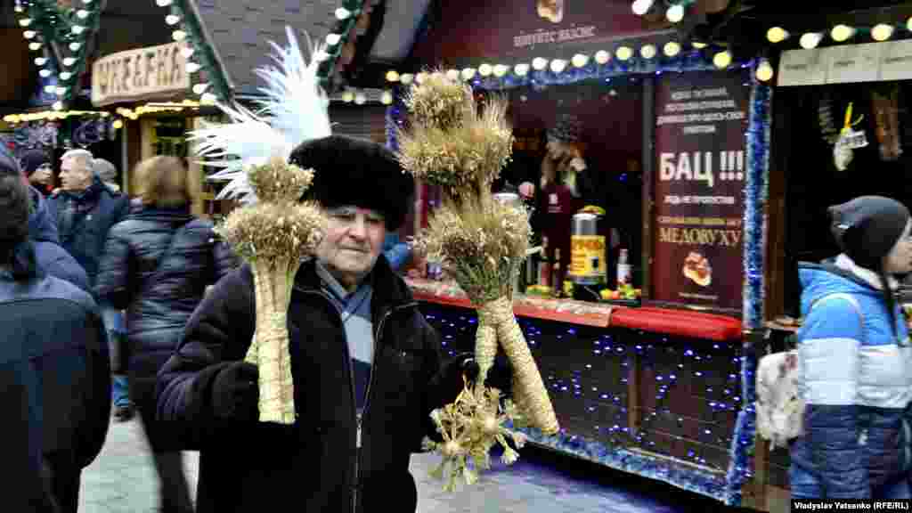 Цей чоловік продає дідухів, які виготовляє власноруч. Дідух &ndash; символ урожаю, добробуту, багатства, оберіг роду. Він є одним із найдавніших культів у різдвяній обрядовості українців, такими дідухами українські родини прикрашають свої оселі