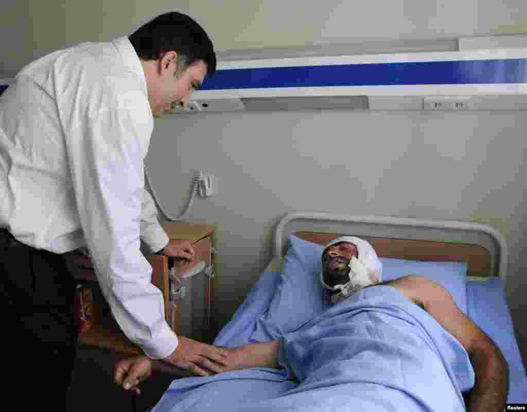 President Mikheil Saakashvili speaks to an injured Georgian soldier during a visit to a military hospital in Gori, about 80 kilometers from Tbilisi, on August 7, 2008. Russia accused Georgia of triggering clashes with South Ossetian rebels and Russian forces in the breakaway Georgian region of South Ossetia.